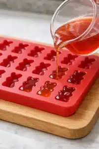 homemade gummy bears Filling gummy bear molds with mixture